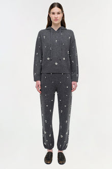 Charcoal cashmere hoodie and jogger set with scattered crystal embellishments throughout, worn with black loafers.