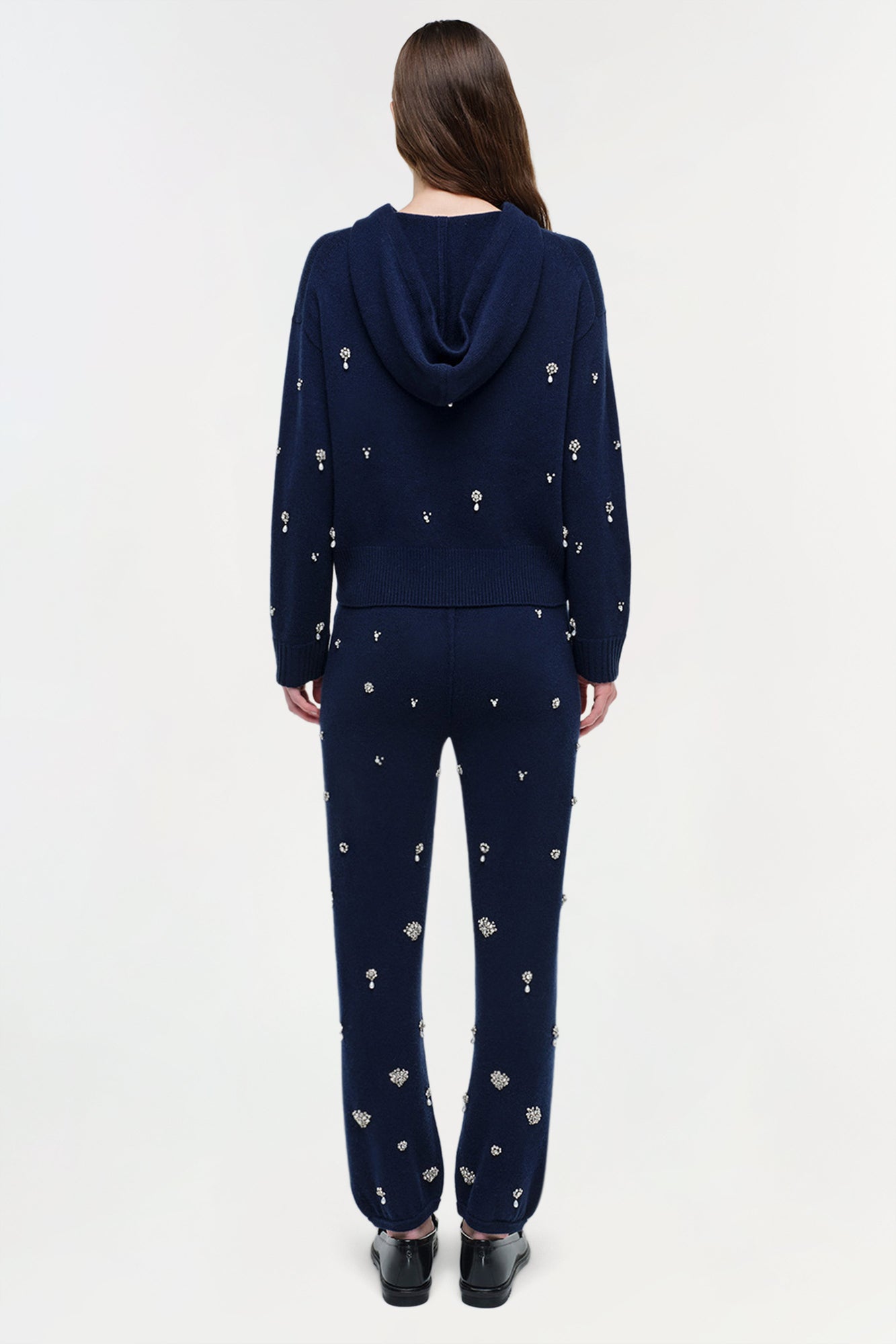 Navy cashmere hoodie with scattered crystal embellishments throughout, shown from back on model wearing matching embellished 