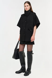 Black wool cape jacket with button front, high collar, and short sleeves on model.