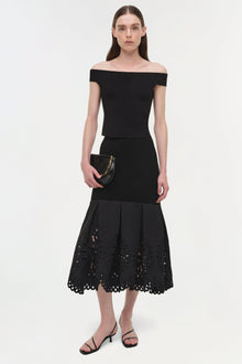 Black knit midi skirt with eyelet embroidery at the hem, modeled with off-shoulder top.