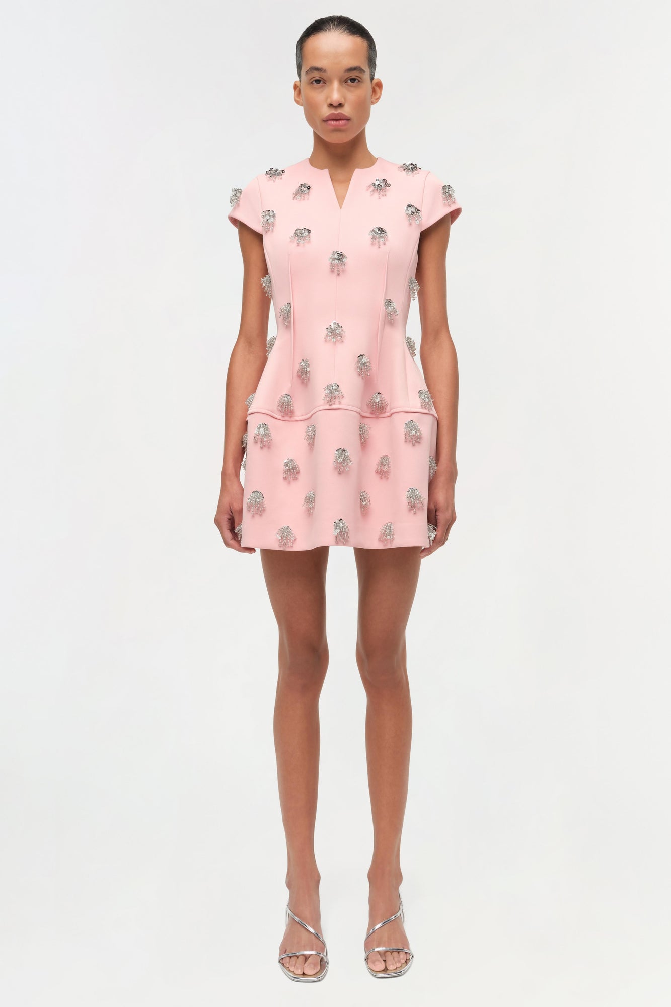 Pink mini dress with silver beaded embellishments throughout, short sleeves, V-neckline, and tiered skirt.