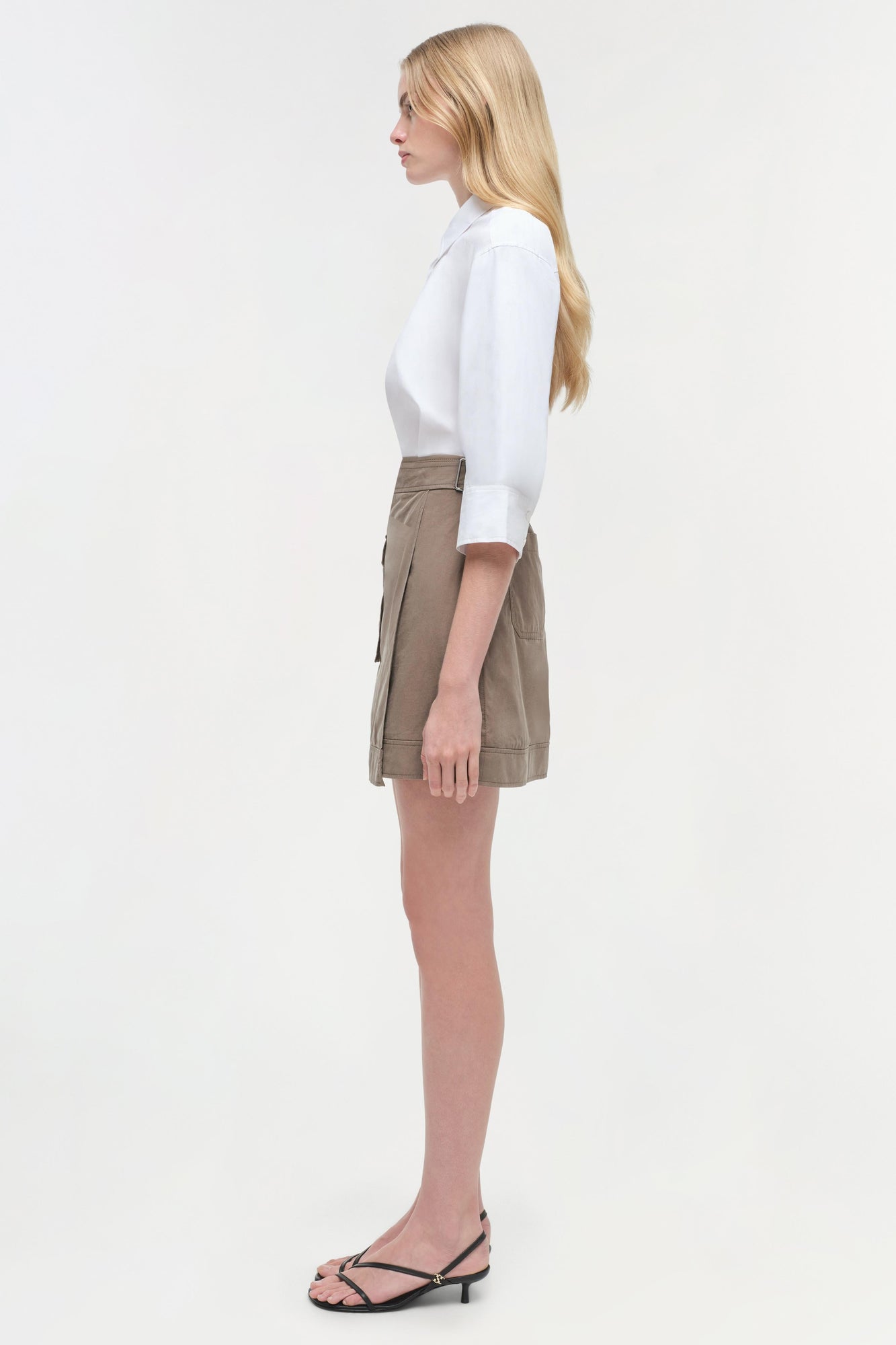 White button-up shirt with three-quarter sleeves paired with taupe cargo mini skirt.