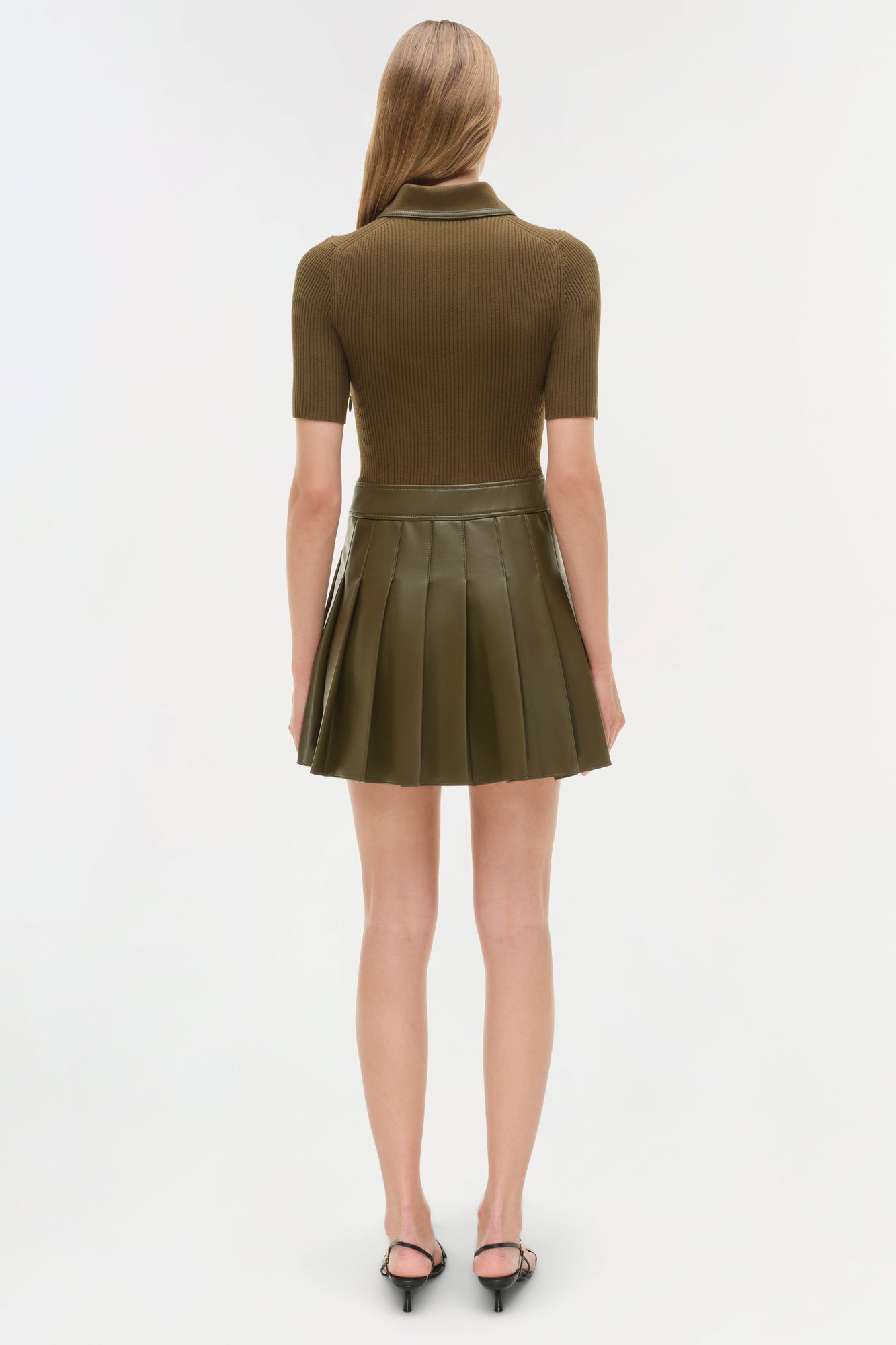 Olive knit mini dress with short sleeves, collared neckline, and pleated skirt, shown on model from back view.