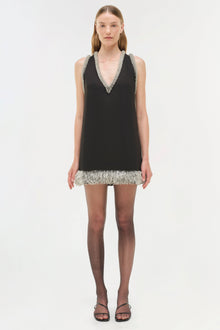 Black sleeveless mini dress with silver beaded V-neckline and fringe hem detail.