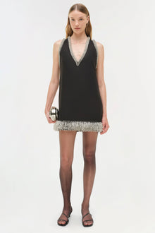 Black sleeveless mini dress with crystal-embellished V-neckline and matching beaded hem trim.