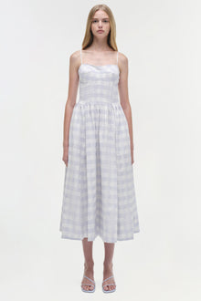 Light lavender gingham cotton midi dress with thin straps and fitted bodice worn with white sandals.