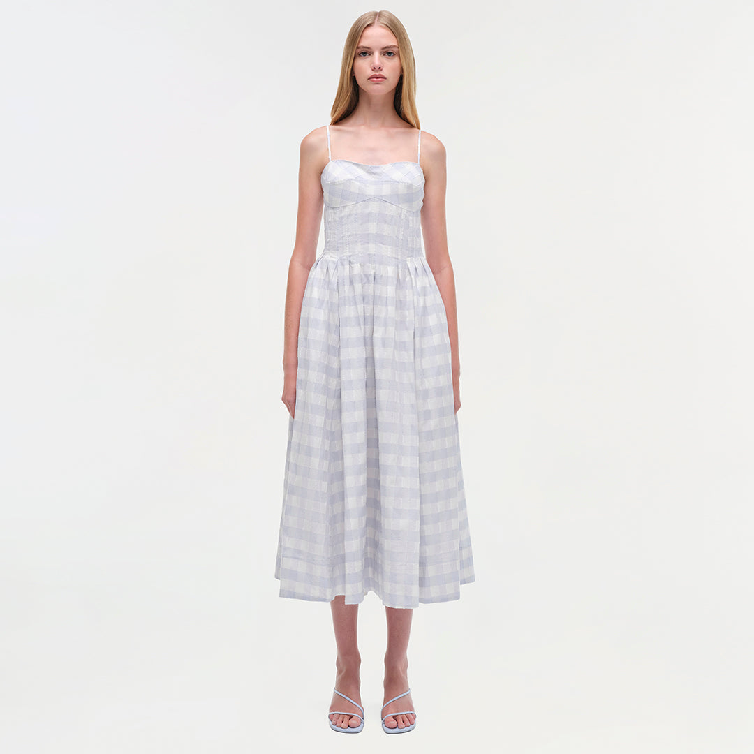 White gingham cotton midi dress with thin straps and fitted bodice on a model.
