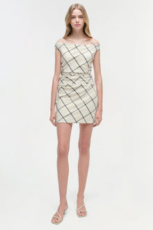 Cream mini dress with diagonal grid pattern and off-shoulder neckline, styled with white sandals.