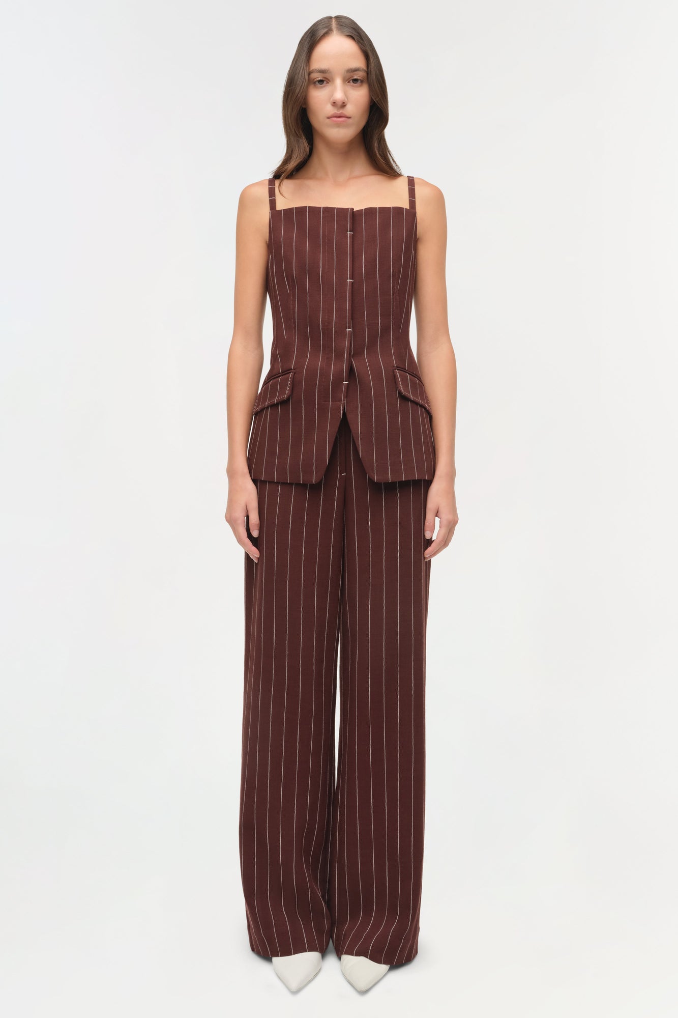 Burgundy pinstriped sleeveless top with square neckline, button front, and structured pockets on model wearing matching wide-