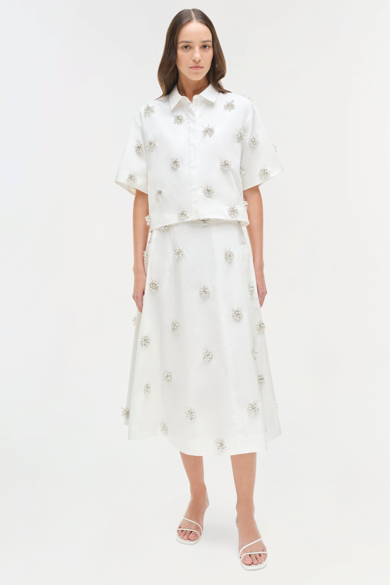 White camp shirt with silver beaded floral embellishments throughout, paired with matching midi skirt.