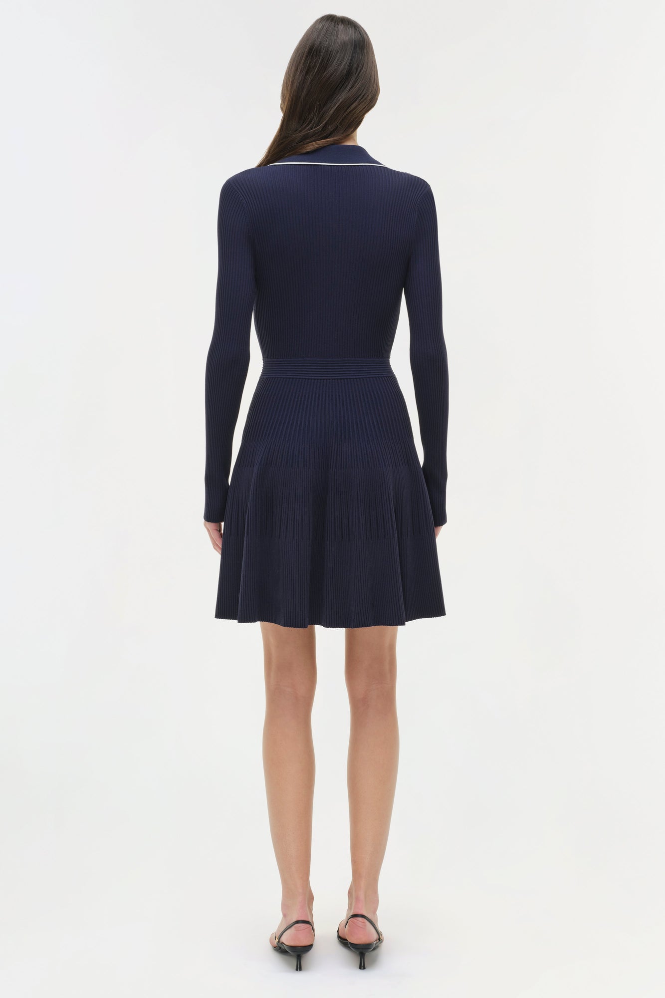 Navy ribbed knit mini dress with collared neckline and pleated skirt, shown on model from back view.