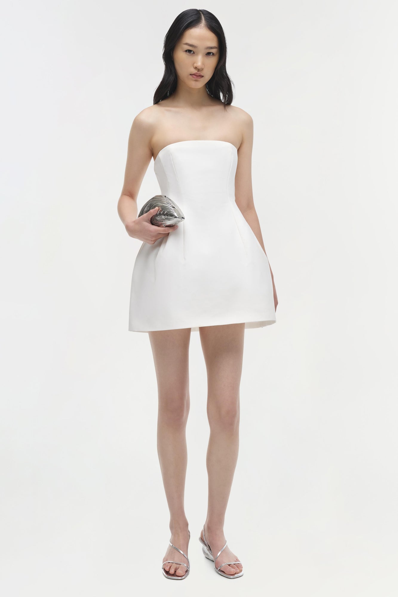 White strapless mini dress with fitted bodice and flared skirt hem.