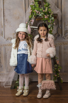 Girl holding dusty pink organza ruffle handbag, highlighting the gold strap detail that matches the gold frame closure