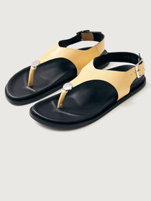 Buttery yellow colored sandal with black sole and silver hardware. 