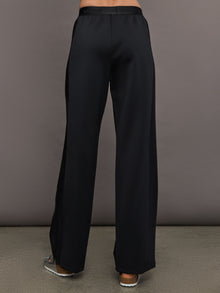 Model wears black wide leg pants with an elastic waistband. 