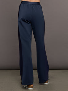 Model wears navy wide leg pants with an elastic waistband. 