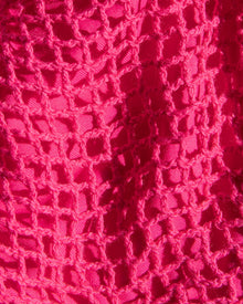 Close-up of a textured pink fabric with a crochet pattern