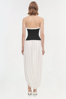 Strapless dress with black fitted bodice and white pleated draped skirt, shown from back view.