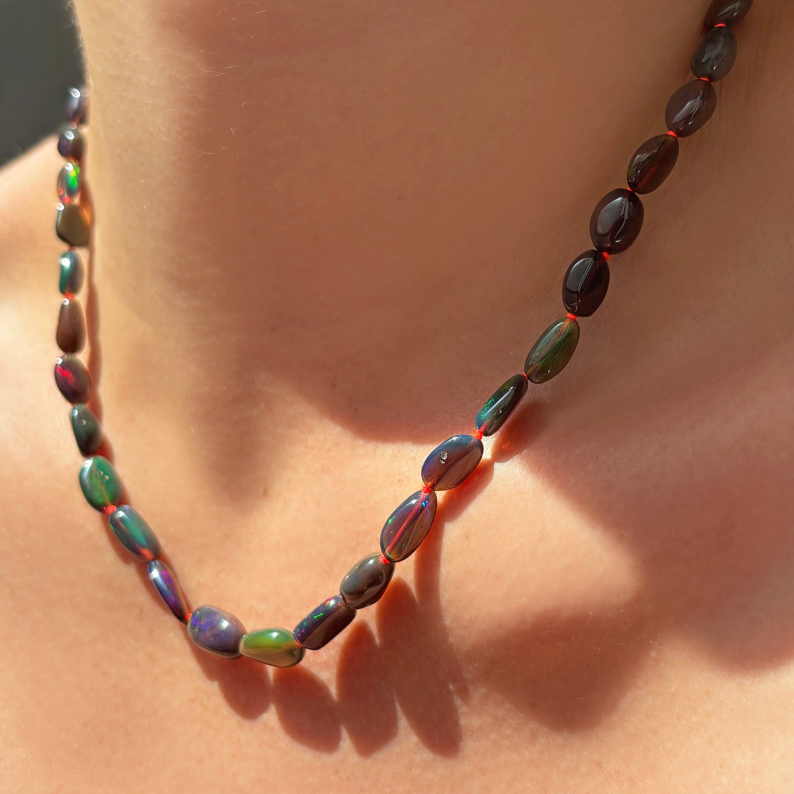 Black Opal Nugget Necklace with Neon Red Thread on the neck.