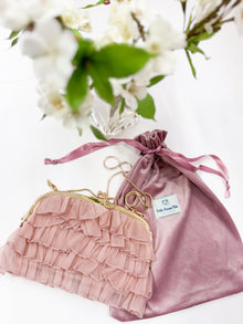 Dusty pink organza ruffle handbag displayed with gold chain strap and matching pink velour dust bag 