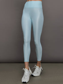 Model wears a pair of high rise baby blue sleek liquidy shine leggings. 
