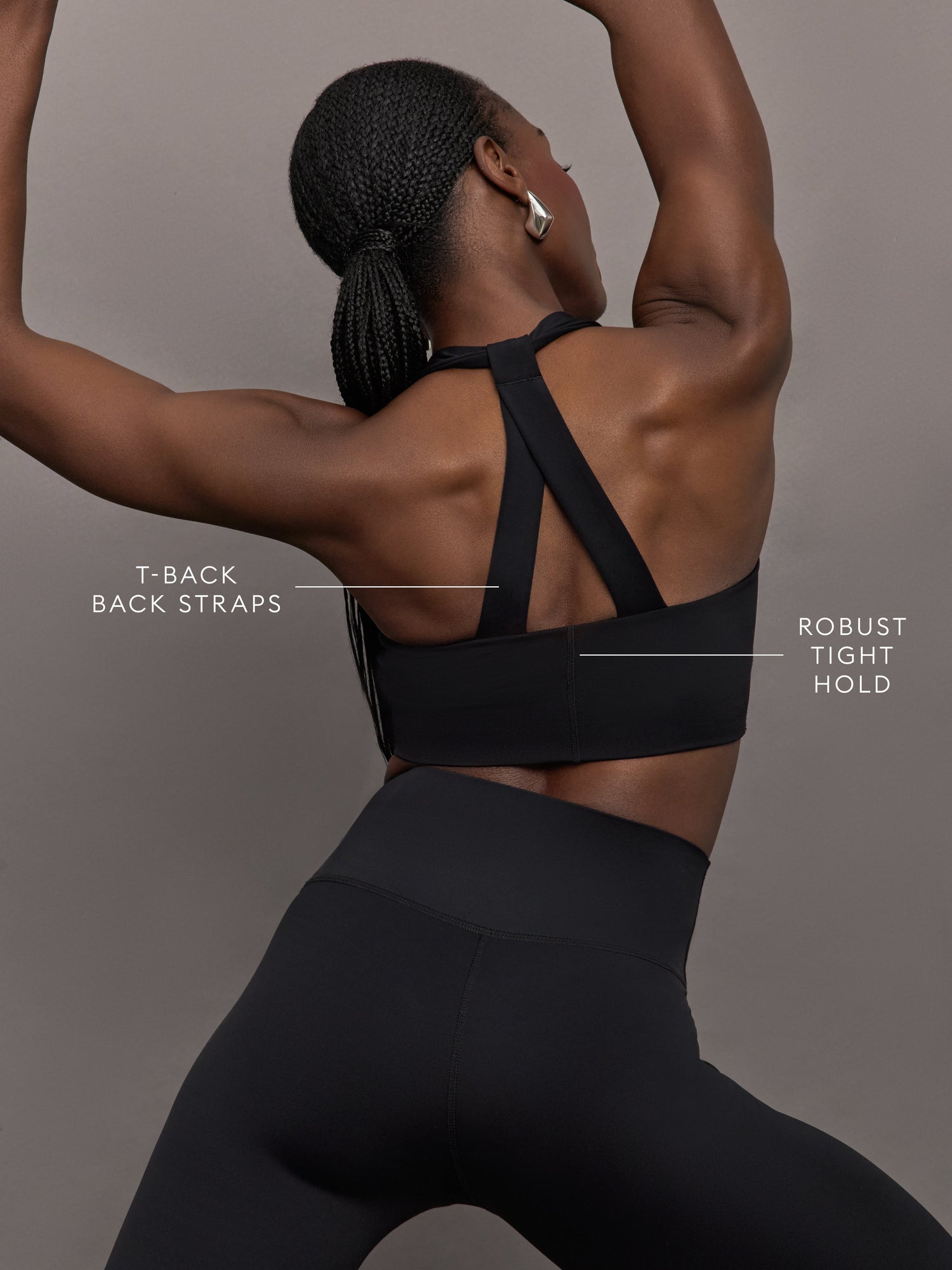 Model stretching in black diamond compression T-back bra, racerback detail.