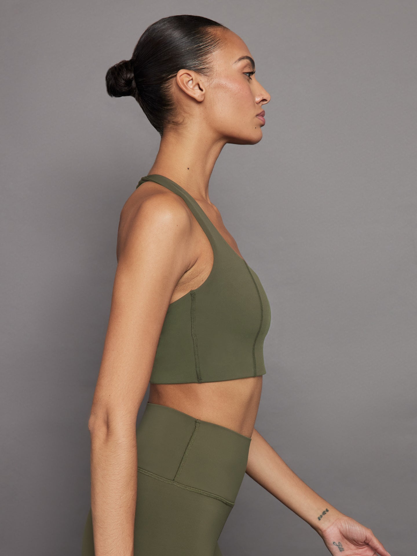 Side profile of olive Diamond Compression T Back Bra with halter neckline.