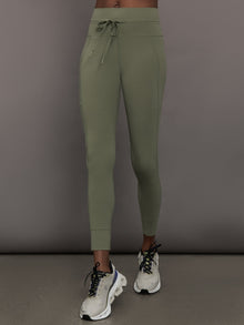 Model is wearing Melt High Rise Sport Pocket Legging in Moss, front view.