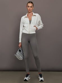 Model is wearing Ribbed Melt High Rise Legging in Steel Grey with cropped zip jacket, full body view.