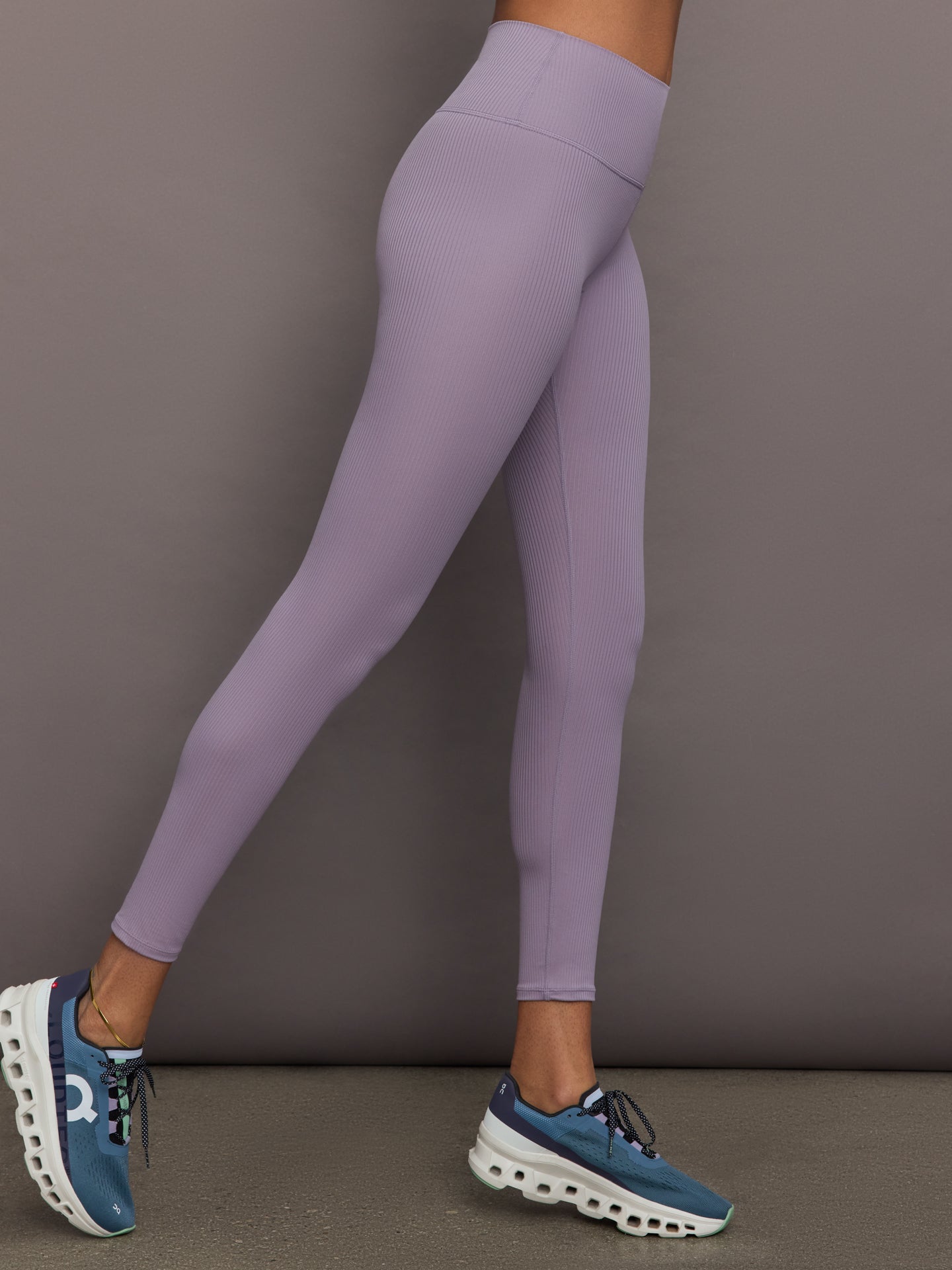 Model wears lavender grey, high-rise ribbed leggings with a fitted, full-length silhouette.