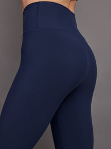 Model wears navy high-rise, full-length leggings with a matte finish and a smooth, body-hugging fit.
