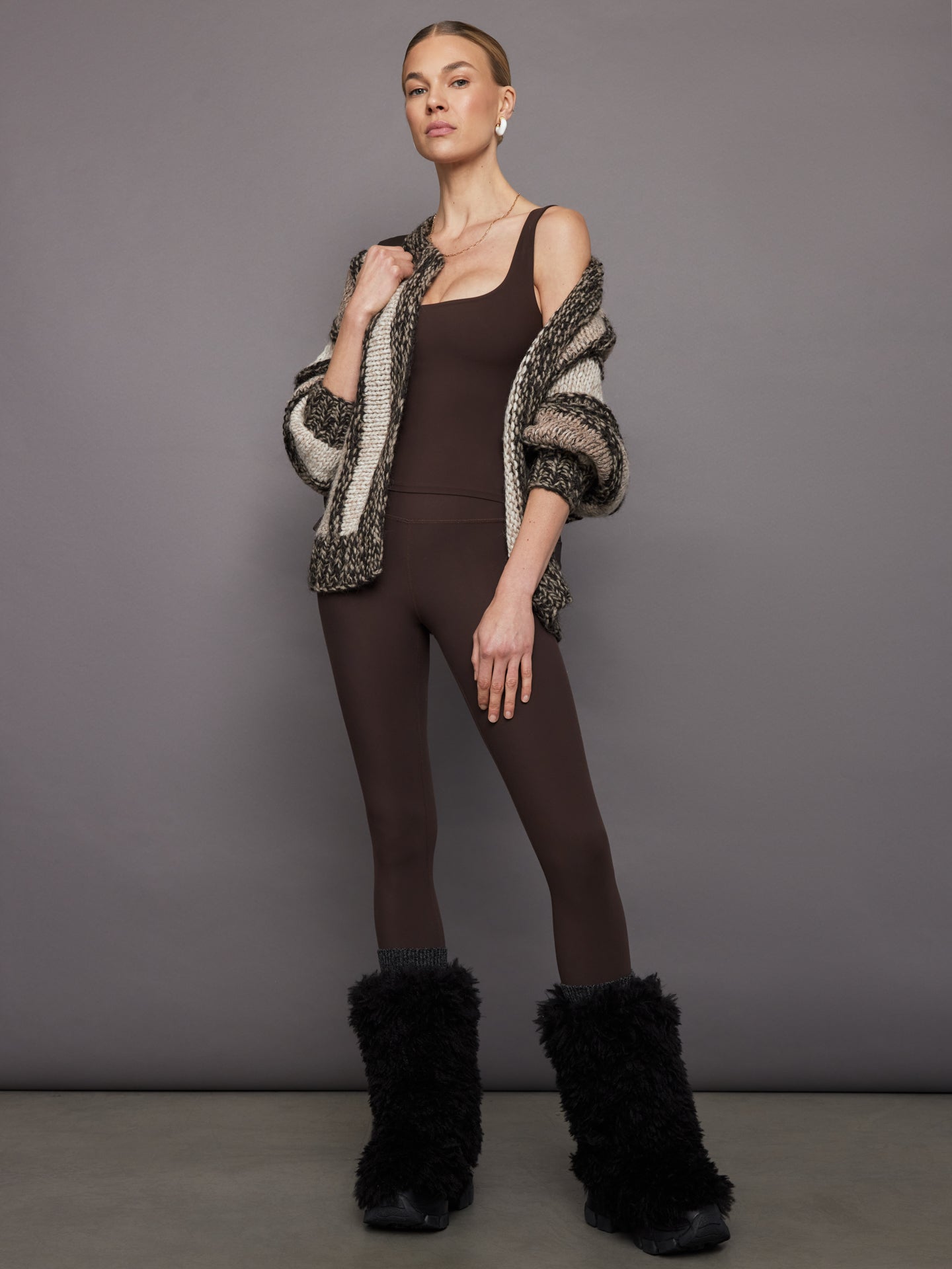 Styled look of Melt wide scoop bra tank in Dark Oak with striped knit cardigan and leggings.