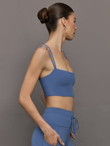 Side profile of Blue Horizon strappy sports bra on model.