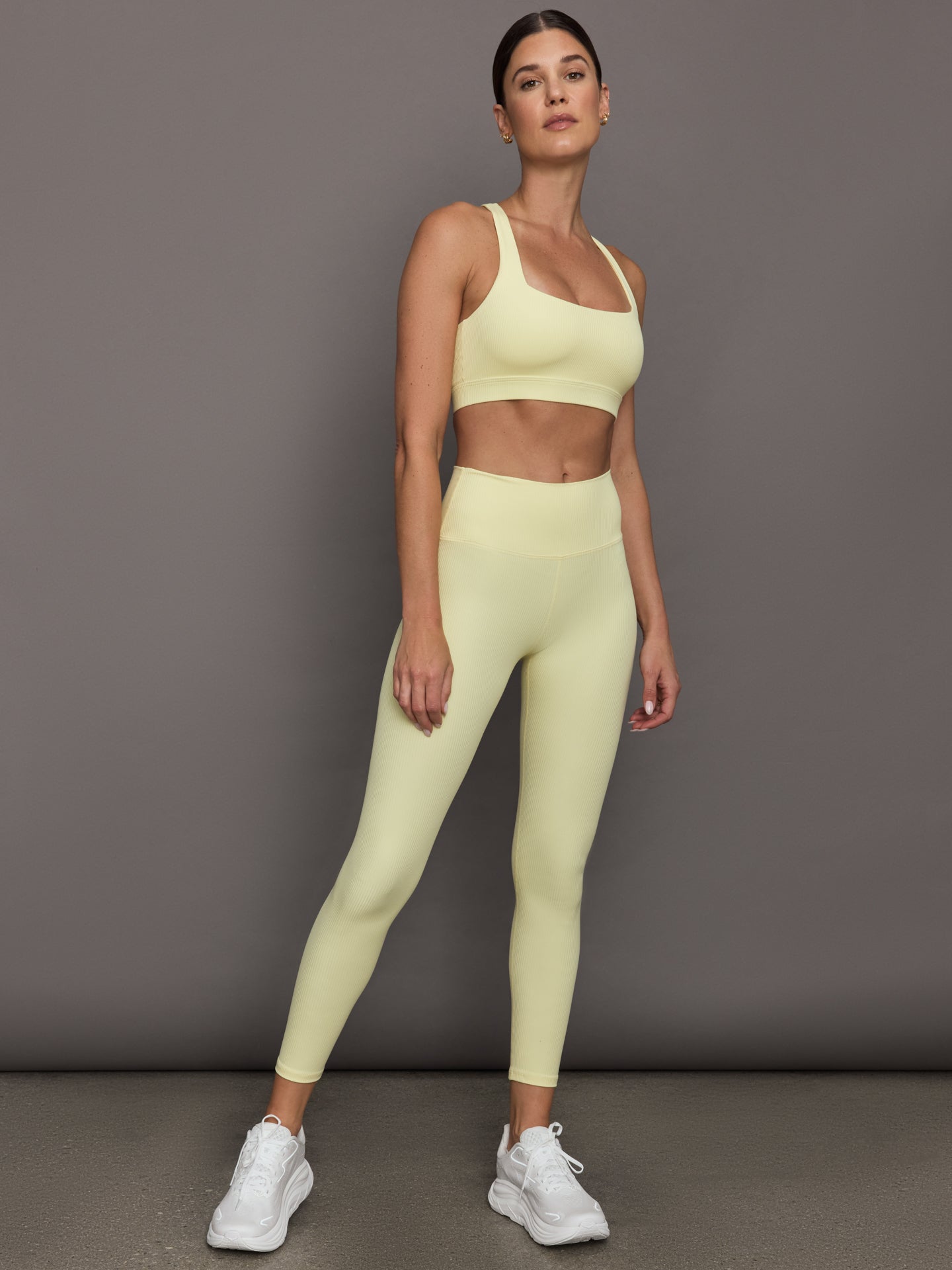 Model wears a buttery soft, ribbed pastel yellow square neck bra with a racerback silhouette. 