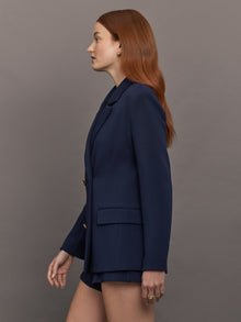 Model wears the Navy double-breasted blazer in Scuba, with a tailored fit, and a smooth, contoured finish.