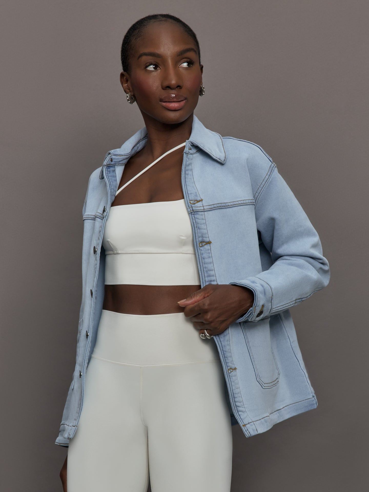 Model wears a light washed denim shirt jacket.
