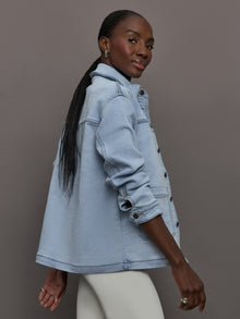 Model wears a light washed denim shirt jacket.