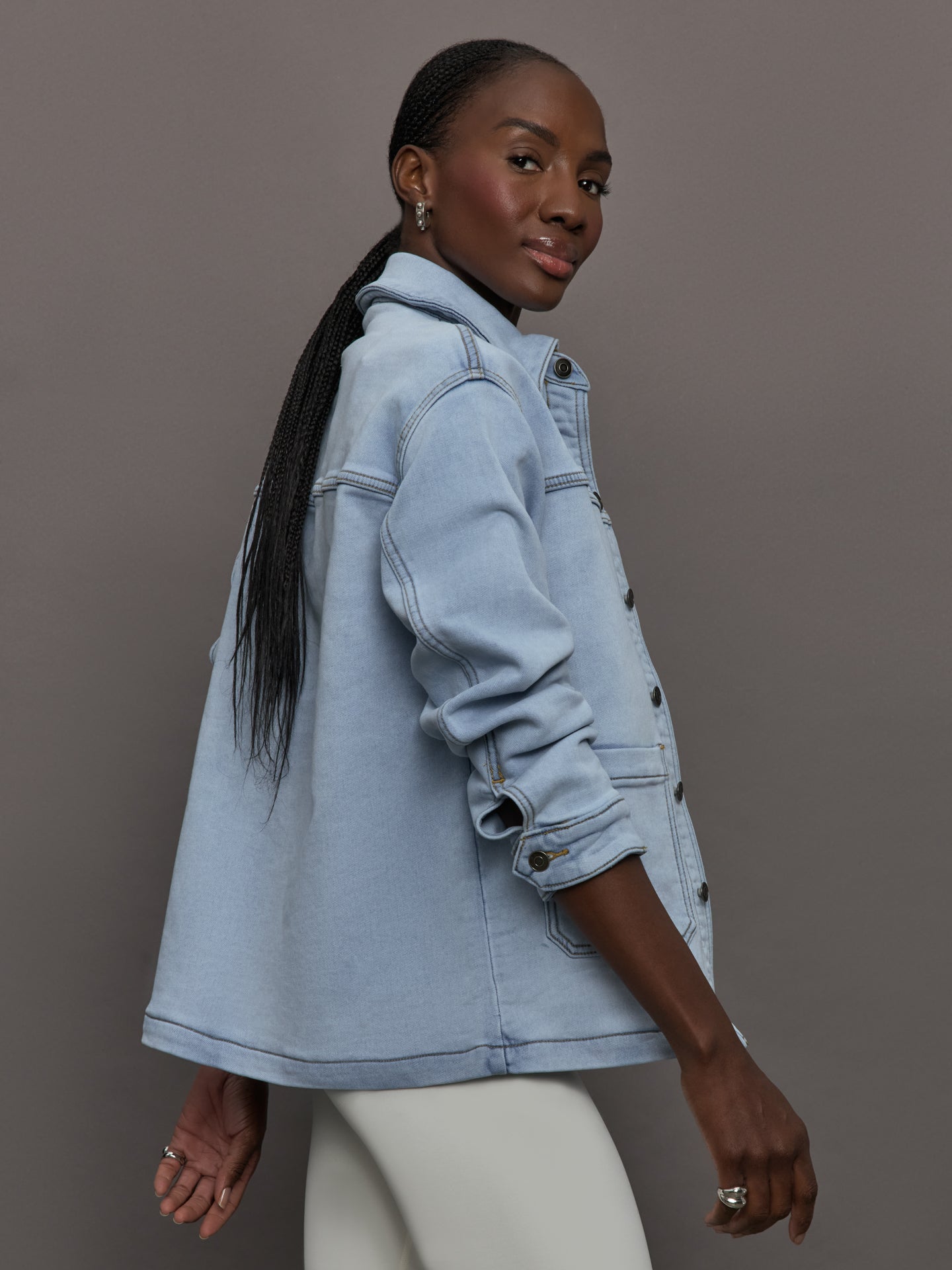 Model wears a light washed denim shirt jacket.