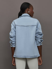 Model wears a light washed denim shirt jacket.