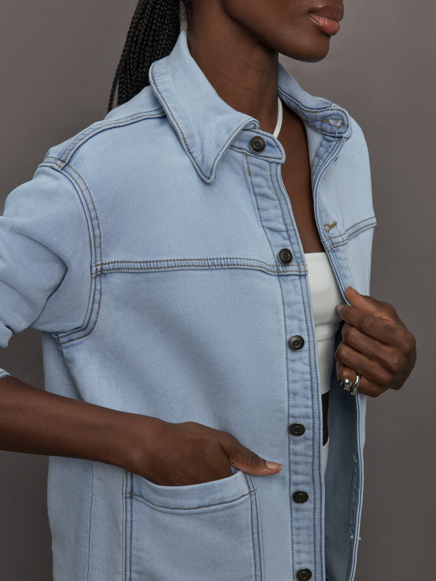 Model wears a light washed denim shirt jacket.
