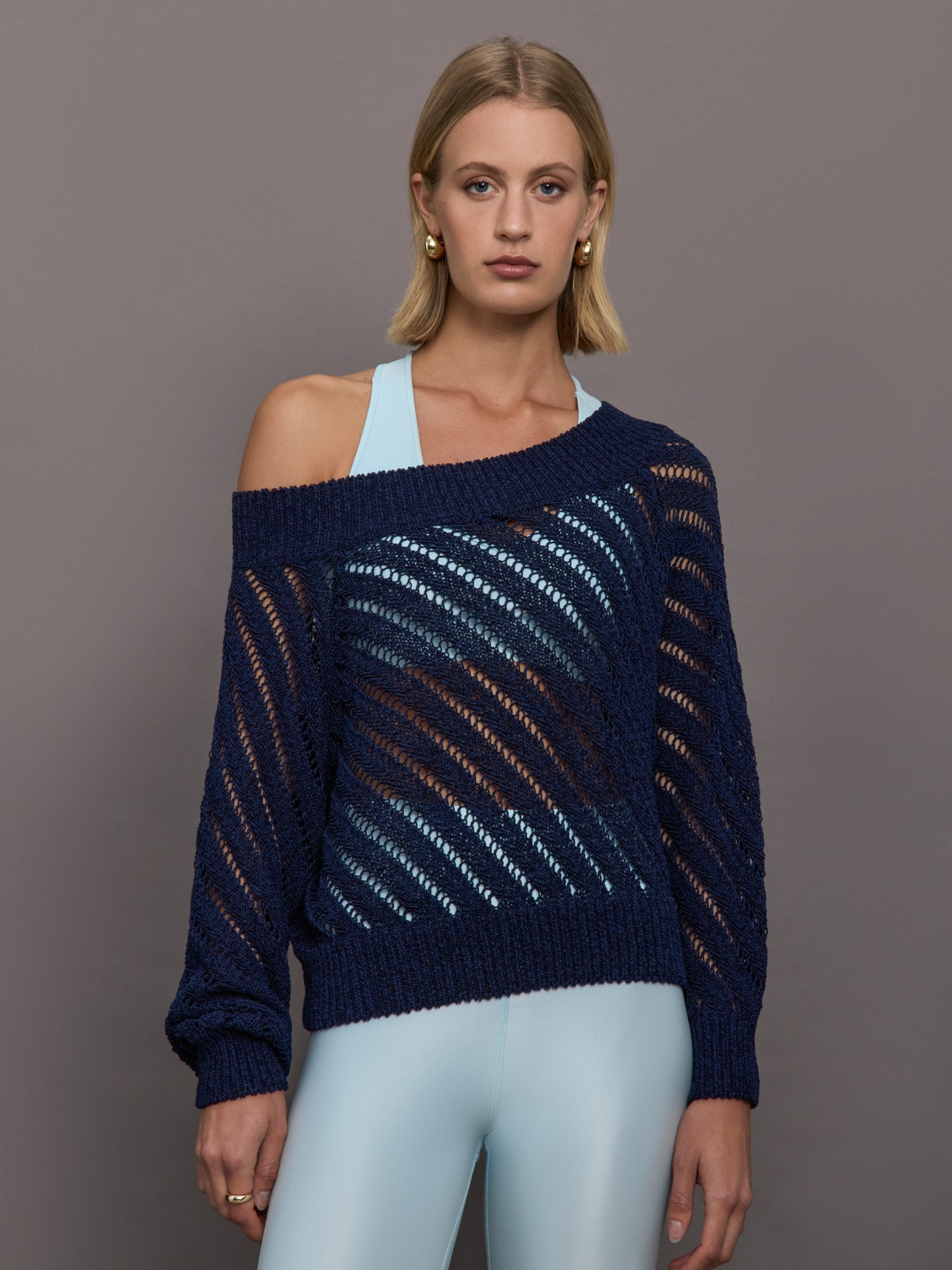Model wears a navy off shoulder mesh cardigan with diagonal pattern. 