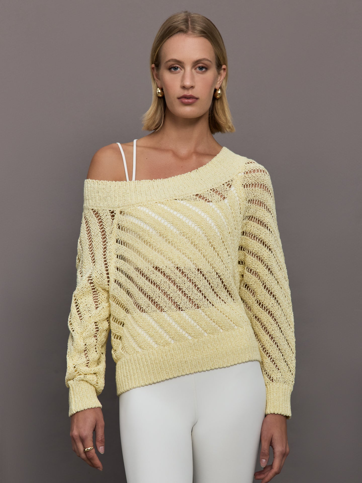 Model wears a yellow off shoulder mesh cardigan with diagonal pattern. 