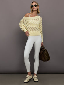 Model wears a yellow off shoulder mesh cardigan with diagonal pattern. 