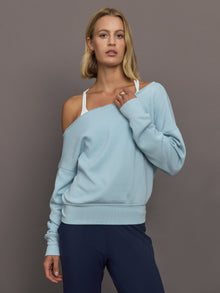 Model wears a light blue off shoulder french terry sweatshirt. 