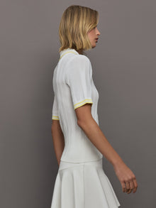 Model wears a lightweight and breathable polo tee shirt with yellow collar and sleeve details. 