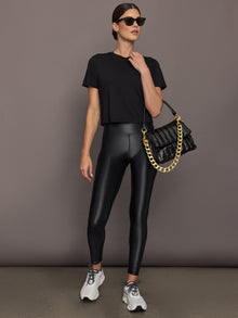 Model wears a cropped boxy black tee shirt. 