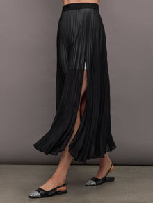 Side view of model wearing Mesh Pleated Sheer Skirt Black with slit detail.