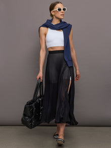 Full front view of model styled in Mesh Pleated Sheer Skirt Black with white crop top and black tote.