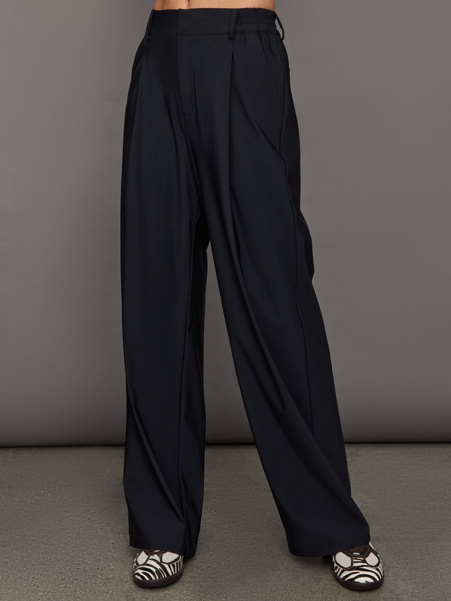 Model wears a pair of black wide leg versatile trousers. 