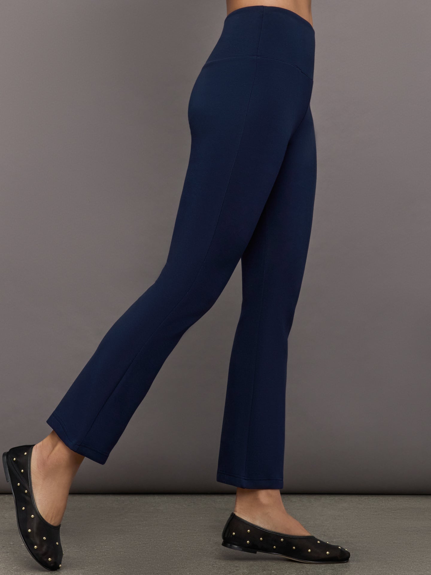 Navy high-rise pants with a fitted, sculpting silhouette through the hips and thighs, flaring out subtly at the hem.